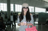 天王嫂熊黛林机场一身灰色运动装很低调，粉红色机车包加超模身段已经足够抢眼。