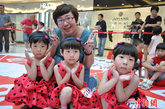 6月26日，沈阳首届双胞胎嘉年华在一家大型商场举行，154对双胞胎参加了“真人多米诺”、“模特走秀”、“两人三足”、“身怀绝技”等多项趣味比赛。双胞胎们年龄最大的55岁，最小的1岁，他们的精彩表演为沈阳市民送去一份欢乐。中新社发 司晓帅 摄
