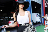 金·卡戴珊(Kim Kardashian)
一件黑白拼接的吊带连衣裙优雅不失性感，腰间的铆钉腰封带来一丝酷感味道，大大的黑色圆边遮阳帽很有名媛气息。

