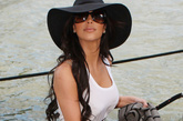 金-卡戴珊(Kim Kardashian)：一件黑白拼接的吊带连衣裙优雅不失性感，腰间的铆钉腰封带来一丝酷感味道，大大的黑色圆边遮阳帽很有名媛气息。