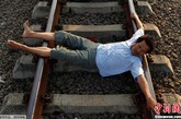 印度尼西亚西爪哇省的居民横卧在铁轨上，他们相信铁轨上的电流可以帮助人们治愈各种疾病。(来源：中国新闻网)
