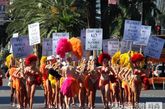 当地时间2011年7月21日，拉斯维加斯，众多比基尼女孩戴着夸张的羽毛头饰街头游行，高举牌子反对“求助费”，十分引人注意。 (图片来源：东方IC)
 
 
 

