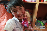 7岁的玉珍在玩具室抱着这个娃娃幸福地笑着说：我太喜欢她了（图片来源：凤凰网华人佛教  摄影：丹珍旺姆）