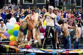 荷兰阿姆斯特丹。参加一年一度的“同性恋自豪”水上游行的人们。今年游行的主题是“我们同在”，共有80只游行船在阿姆斯特丹运河上航行。
