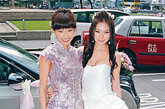 香港组合2R成员在结婚时也选择了旗袍，这件粉色绣花旗袍就要显的更加的中规中矩。在下摆处并没有运用传统的旗袍设计而是采用了如西式礼服般的散摆，中西合并，别有韵味。