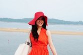 橘红色的连衣裙十分适合度假穿着，在蓝天白云的衬托下十分上像，也显的人气色红润而健康。