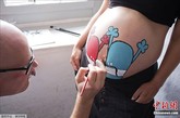 当地时间8月12日，丹麦哥本哈根举行了“孕妇肚皮彩绘艺术展”，艺术家们在孕妇肚皮上当场做画。据悉，此次艺术展的收入将捐献给全球产妇保健组织。