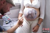 当地时间8月12日，丹麦哥本哈根举行了“孕妇肚皮彩绘艺术展”，艺术家们在孕妇肚皮上当场做画。据悉，此次艺术展的收入将捐献给全球产妇保健组织。（图片来源：中国新闻网）