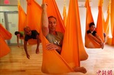 8月16日，美国纽约的一家健身所内，“反重力”瑜伽的练习者们正在吊床上做着各式瑜伽动作。与传统瑜伽不同，“反重力”瑜伽练习者需借助从屋顶吊下的丝质吊床完成所有动作。据悉，这种吊床可以帮助练习者获得更大的灵活度，让动作更为舒展。