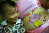 2011年8月18日，海南海口一家妇幼医院里，彩绘师在5名孕妈妈隆起的肚皮上描绘“大运会吉祥物UU”、“兔子”等图案。孕妈妈们以此健康的方式来欢庆大运会举行，并对宝宝的诞生前而纪念。   