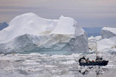 一艘渔船在冰山间穿行——这些冰山崩裂形成于格陵兰岛伊卢利萨特附近的格陵兰岛冰原。
