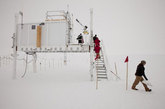 在这张2011年7月15日的照片中，一座安装了传感器的小型实验室结构在“峰顶站”耸立着——这处偏远的研究站点由美国国家科学基金会（NSF）运作，海拔1万500英尺，位于格陵兰岛冰原的顶部。横跨格陵兰岛白色地域，由世界各地的研究者组成的小团队正在搜寻关于全球变暖对格陵兰岛的冰构成潜在影响的线索。