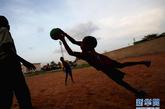 8月17日，在塞内加尔首都达喀尔郊区，一个小球迷进行射门练习。新华社记者 刘宇摄