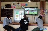 8月20日，在塞内加尔首都达喀尔以北的玫瑰湖附近，几个球迷在餐馆收看欧洲职业联赛的转播。新华社记者 刘宇摄