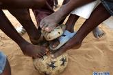 8月18日，在塞内加尔首都达喀尔市中心的一块空地上，孩子们在比赛前把脚放在足球上。新华社记者 刘宇摄