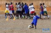 8月23日，在塞内加尔首都达喀尔郊区，在专业队员进行赛前训练时，一个小球迷在一旁练习球技。新华社记者 刘宇摄