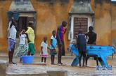 8月21日，在塞内加尔首都达喀尔郊区，孩子们冒雨玩桌上足球游戏。新华社记者 刘宇摄