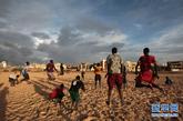 8月20日，在塞内加尔首都达喀尔的海滩上，刚刚进行完足球比赛的球员进行身体训练。新华社记者 刘宇摄