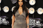 新婚不久的好莱坞真人秀明星金·卡戴珊(Kim Kardashian)照样要来捧场：她身着Kaufman Franco2012早春度假系列的V领银色连身裙亮相。