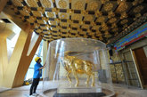 图为工作人员在江苏江阴华西村“新农村大楼”观看安放好的1吨重金牛。