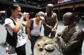 2011年9月6日，上海，作为今年上海旅游节和上海购物节系列活动，豫园中国日（节）豫园“非遗文化节”暨中华老字号文化展活动9月7日至10月7日在豫园商城中心广场举行，通过技艺展示、文化宣传、产品介绍等方式，进一步推广和传承中华文化与传统技艺。 品酒吃五香豆的雕塑吸引游客