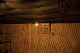 平壤战争博物馆内，一张金日成的照片的前方，挂着一枚用手榴弹做成的电灯泡。现场摆设模拟了日占时期朝鲜士兵抵抗所用的地下根据地。
