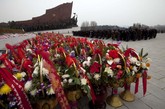 人们为一座万寿山脚下一座纪念已逝伟人金日成的纪念碑献花。为了纪念金日成，4月15号是朝鲜法定节日：太阳日。这些花圈是在这个节日到来之际献上的。
