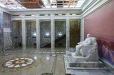 一座金日成的铜像“坐”在平壤人民学习大礼堂的大厅入口处。
