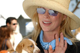 金·贝辛格（Kim Basinger）

Kim一袭黑色着装配上蓝色丝巾相当贵气优雅，大大的草帽为她遮挡阳光的同时更增添了造型感。怀里可爱的狗狗相当温顺的样子让Kim充满了母性气息。
