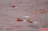 图为落水者在湍急的江水中挣扎。