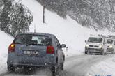 在奥地利西部蒂罗尔州首府因斯布鲁克以南20公里的一个村庄，汽车经过白雪覆盖的山坡。