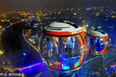游客在摩天轮的球舱内观赏广州夜景，下面是广州的母亲河珠江。