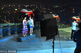 在广州塔顶的观景平台，游客以摩天轮为背景拍照留念。