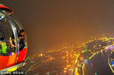 游客在摩天轮的球舱内观赏广州夜景。