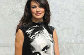 玛莉亚·嘉西亚·古欣娜塔（Maria Grazia Cucinotta在2012春夏米兰时装周上身着Emporio Armani黑色裙亮相，大大的头像印在群身上十分惹眼。
