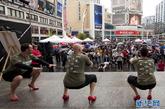 近日在加拿大多伦多邓达斯广场，几位穿着高跟鞋的男士尝试下蹲动作。