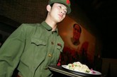  2006年4月7日，北京的一家“红色经典餐厅”，一位打扮成红卫兵模样的服务员走过已故毛泽东主席的肖像。“红色经典”是一家基于发生在1966年至1976年中国文化大革命的主题餐厅。餐厅装饰着那时期的海报，服务员打扮成当时的红卫兵，表演文革时期的歌曲和舞蹈。