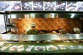 2008年6月27日，黎巴嫩贝鲁特“包子和枪支”快餐店里身穿军队T恤的厨师。该军事主题的餐厅位于黎巴嫩首都贝鲁特真主党控制的南部郊区。餐厅的厨师穿戴着军事装备，顾客坐在沙袋墙的后面。食物上方的标语写道“一个三明治可以杀了你！” 
