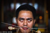 国普吉岛，泰国素食节上演惊悚"铁杆穿肉"。寺庙信徒用橡皮管穿过脸部。泰国素食节的历史可追溯到17世纪初叶。节日开始于农历初九的第一天晚上，一直持续九天。参加素食节人现场表演“铁杆刺肉”，寓意是摆脱体内邪灵，给生活社区带来好运。
