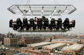 2006年4月24日，在交通繁忙的比利时布鲁塞尔的50米高空，起重机吊起的一张餐桌上，一组22位厨师正品尝着一盘生蚝。