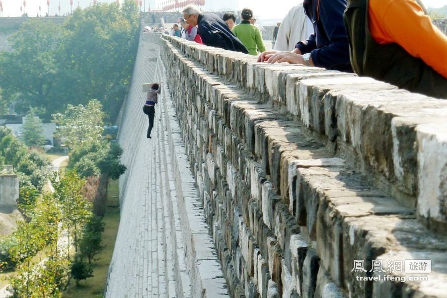 女子徒手爬上20米高南京明城墙 疑为逃票