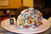 日本一家名叫“Umewaka"的餐馆为顾客供应世界最大的寿司卷，这个巨大的寿司卷，耗费了20多种食材，长达2米，重约6公斤。据说是平时20多人吃的量。一个这样的超大寿司卷，售价是15000日元。