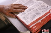图为一位老妇人翻开她插满标签的《圣经》，这位居住在承德的妇人已经信基督教10年，经常会在坐6417时翻阅《圣经》。 中新社发 张浩 摄