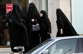 利雅得，身穿长袍的妇女们在路边等车。