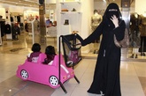 吉达，一名沙特妇女带着孩子在商场逛街购物。