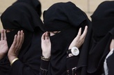 关于妇女的权利和地位问题在沙特一直是倍受争议，妇女得到选举权是沙特妇女权利的一次历史性飞跃。图为沙特首都利雅得，妇女们头戴面纱在宰牲节庆祝活动上祈祷。黑纱掩盖不住高档的镶钻手表。