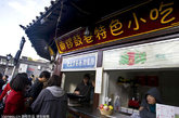 2011年10月15日，北京，游客在品尝锣鼓巷特色小吃。