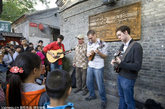 2011年10月15日，北京，两名小朋友在观看外国艺人街头演唱。