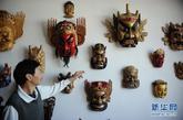 木雕艺人彭焕连在展示雕刻的赣西傩面具。