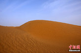 深秋时节，新疆塔克拉玛干沙漠尽显天地造化的万种风情。塔克拉玛干沙漠位于中国新疆的塔里木盆地中央，是中国最大的沙漠，也是世界第二大沙漠，同时还是世界最大的流动性沙漠。整个沙漠东西长约1000公里，南北宽约400公里，面积达33万平方公里。塔克拉玛干维吾尔语意为“进去出不来的地方”，当地人通常称它为“死亡之海”。孙自法 摄
